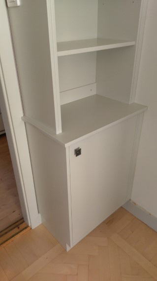 Vägganpassad bokhylla med bänkskåp